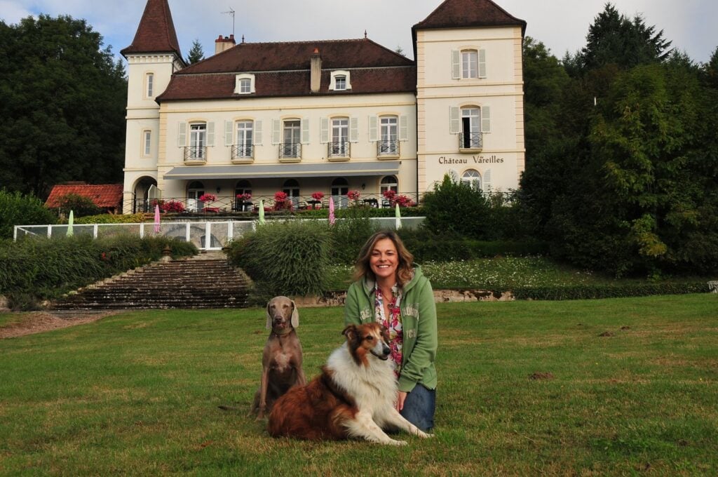 Alice Häuser mit Maya und Pflegehund Shakira vor einem Château in Frankreich.